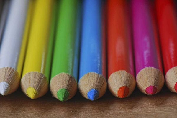 Row of multicolored colored pencils lay on table